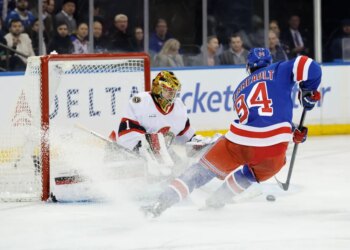 New York Rangers player Gabe Perreault scores a goal past Senators goalie Leevi Merilainen.