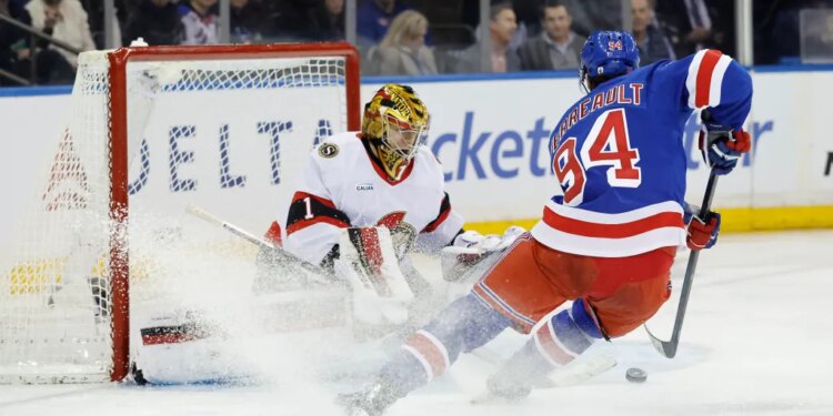 New York Rangers player Gabe Perreault scores a goal past Senators goalie Leevi Merilainen.