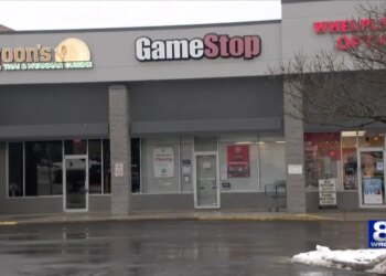 The exterior of a GameStop store with a "This Store is Closing" sign in the window, next to Moon's Thai & Myanmar Cuisine.