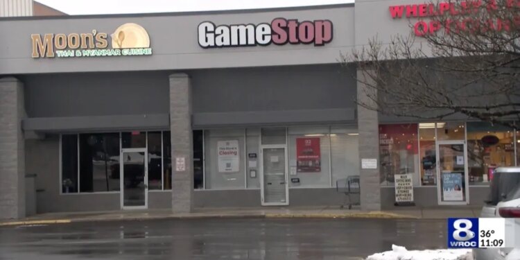 The exterior of a GameStop store with a "This Store is Closing" sign in the window, next to Moon's Thai & Myanmar Cuisine.