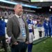 Kevin Abrams, New York Giants executive, wearing a grey jacket, sweater, and white collared shirt, stands on the sidelines of MetLife Stadium.