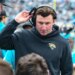 Jacksonville Jaguars offensive coordinator Grant Udinski adjusts his headset on the sideline during a football game.