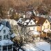 Aerial view of a snowy Rochester suburb with houses and bare trees.