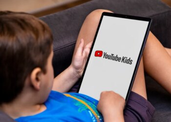 A child views the YouTube Kids logo on a tablet screen.