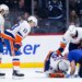 Matthew Schaefer is tended to by a trainer and some teammates  after a Winnipeg goal during the first period of the Islanders' 5-4 road loss to the Jets on Jan. 13, 2025.