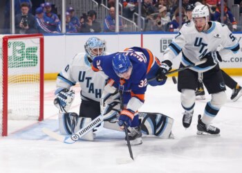 Kyle MacLean #32 of the New York Islanders falls over after he tries to tip in the puck as Karel Vejmelka #70 of the Utah Mammoth and Nick Desimone #57 of the Utah Mammoth defend during the first period when the New York Islanders played the Utah Mammoth Thursday, January 1, 2026 at UBS Arena in Elmont, NY.