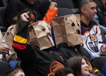 Vancouver Canucks fans wear paper bags on their heads during a 6-0 loss to the Edmonton Oilers.