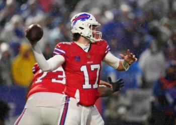 Buffalo Bills' Josh Allen throws the football during a game in the snow.