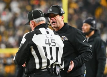 Baltimore Ravens head coach John Harbaugh talks with an official.