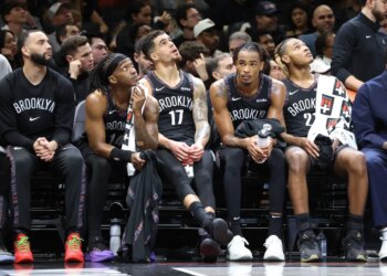 Terance Mann #14 of the Brooklyn Nets along with Michael Porter Jr. #17 of the Brooklyn Nets, Nic Claxton #33 of the Brooklyn Nets and Noah Clowney #21 of the Brooklyn Nets react on the bench during the fourth quarter.