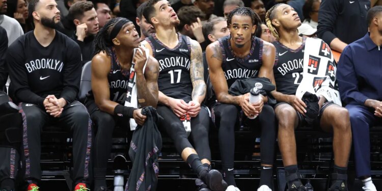 Terance Mann #14 of the Brooklyn Nets along with Michael Porter Jr. #17 of the Brooklyn Nets, Nic Claxton #33 of the Brooklyn Nets and Noah Clowney #21 of the Brooklyn Nets react on the bench during the fourth quarter.