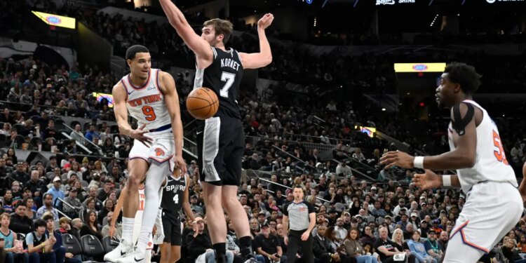 New York Knicks guard Kevin McCullar Jr. (9) passes to Knicks center Ariel Hukporti as he is guarded by San Antonio Spurs center Luke Kornet (7).