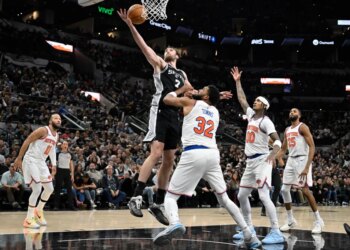 San Antonio Spurs center Luke Kornet (7) grabs the rebound against New York Knicks center Karl-Anthony Towns (32) during the second half of an NBA basketball game, Wednesday, Dec. 31, 2025, in San Antonio.