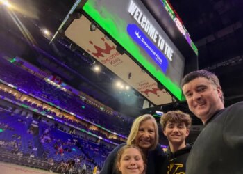 A family of four, including Bubba Watson, taking a selfie at a Lakers game in the Smoothie King Center.