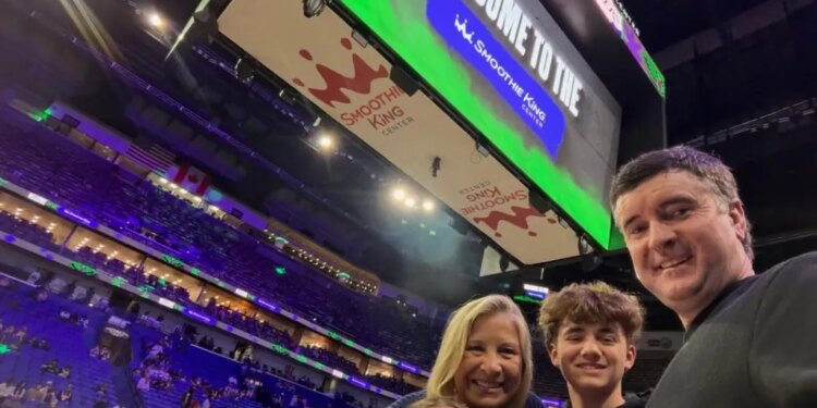 A family of four, including Bubba Watson, taking a selfie at a Lakers game in the Smoothie King Center.