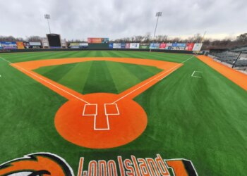Baseball field with green turf and orange dirt.