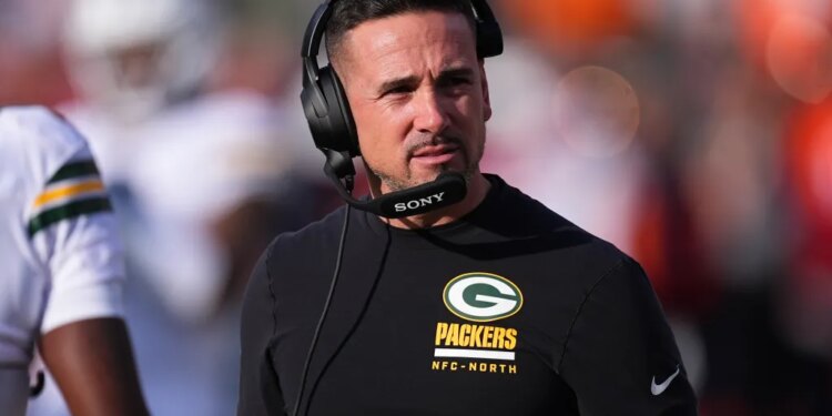 Green Bay Packers head coach Matt LaFleur wearing a headset and a black long-sleeved shirt with the Packers logo.