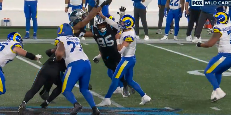 Matthew Stafford bends back a finger during a play against the Panthers in the Wild-Card matchup on Saturday evening.