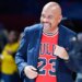 Michael Wilbon, coach of Team Wilbon, smiles while wearing a red Chicago Bulls jersey and a dark blue blazer.