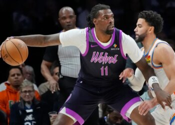 Timberwolves center Naz Reid (11) works around Oklahoma City Thunder guard Ajay Mitchell (25).