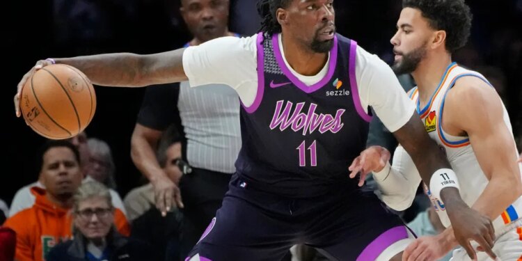 Timberwolves center Naz Reid (11) works around Oklahoma City Thunder guard Ajay Mitchell (25).