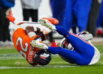 Broncos cornerback Ja'quan McMillian (29) intercepts a pass intended for Buffalo Bills wide receiver Brandin Cooks (18) during overtime of an NFL divisional round playoff football game, Saturday, Jan. 17, 2026, in Denver.