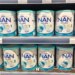 A supermarket shelf stocked with multiple cans of Nestle NAN OPTIPRO baby milk formula.