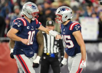 New England Patriots tight end Hunter Henry (85) celebrates with New England Patriots quarterback Drake Maye (10) after scoring a touchdown during the fourth quarter against the Los Angeles Chargers in an AFC Wild Card Round game at Gillette Stadium.