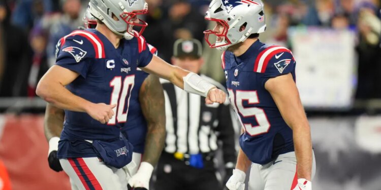 New England Patriots tight end Hunter Henry (85) celebrates with New England Patriots quarterback Drake Maye (10) after scoring a touchdown during the fourth quarter against the Los Angeles Chargers in an AFC Wild Card Round game at Gillette Stadium.