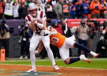 Patriots quarterback Drake Maye scores past Broncos linebacker Justin Strnad in the second quarter of the AFC Championship game in Denver on Jan. 25, 2026.