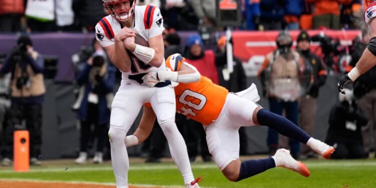 Patriots quarterback Drake Maye scores past Broncos linebacker Justin Strnad in the second quarter of the AFC Championship game in Denver on Jan. 25, 2026.