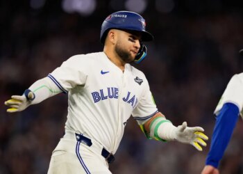 Bo Bichette in a Toronto Blue Jays uniform celebrates a three-run home run.
