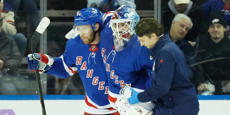 New York Rangers goaltender Igor Shesterkin is helped off the ice by a trainer and New York Rangers defenseman Vladislav Gavrikov after falling back on his leg in the first period at Madison Square Garden in Manhattan, New York, Monday, January 05, 2026.
