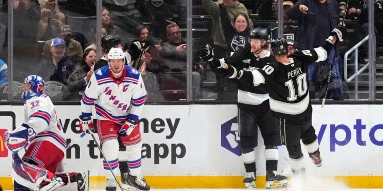 Los Angeles Kings right wing Adrian Kempe, second from right, celebrates his goal with right wing Corey Perry, right, as New York Rangers goaltender Jonathan Quick, left, and center J.T. Miller stand by during the first period of an NHL hockey game Tuesday, Jan. 20, 2026, in Los Angeles.