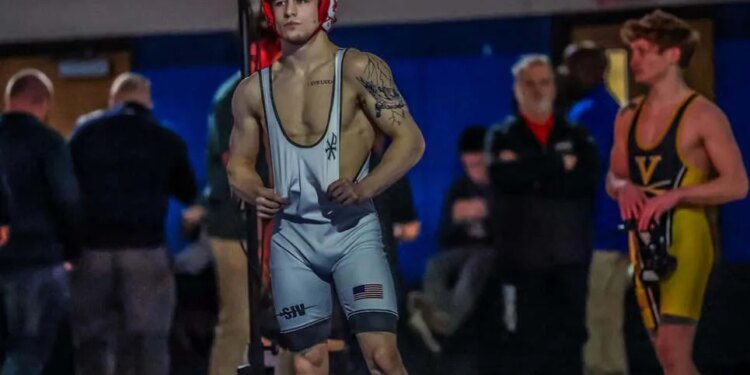 Anthony Knox Jr., a three-time state wrestling champion, stands in his wrestling singlet, facing a competitor.