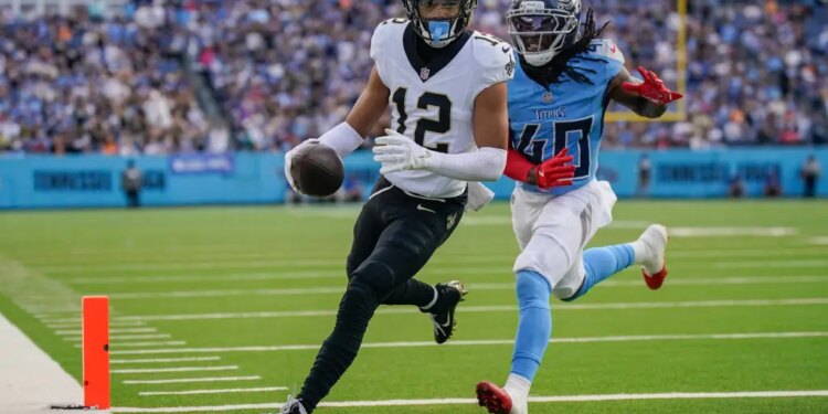 New Orleans Saints wide receiver Chris Olave (12) runs a touchdown in front of Tennessee Titans cornerback Kemon Hall (40)