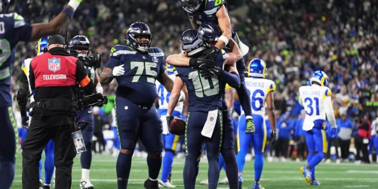 Seattle Seahawks wide receiver Cooper Kupp (10) celebrates his touchdown catch with teammates during the second half of the NFC Championship NFL football game against the Los Angeles Rams Sunday, Jan. 25, 2026, in Seattle.