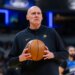 Indiana Pacers head coach Rick Carlisle looking toward the scoreboard while holding a basketball.