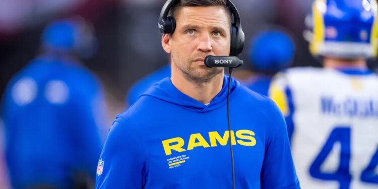 Los Angeles Rams Defensive Coordinator Chris Shula wearing a blue "Rams" sweatshirt and a headset.