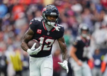 Nico Collins running with the football.