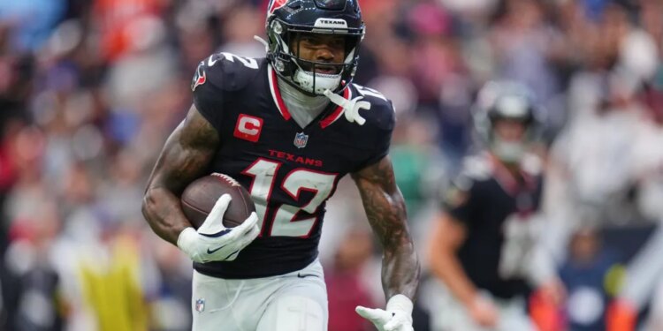 Nico Collins running with the football.