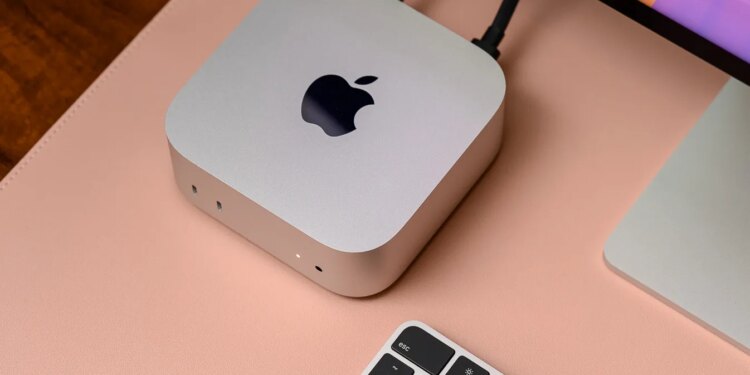 A hands-on photo of Apple’s 2024 Mac Mini on a desk beside a keyboard and Studio Display.