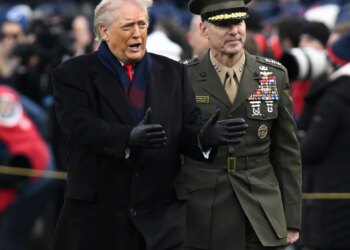 Donald J. Trump and a military officer walking.