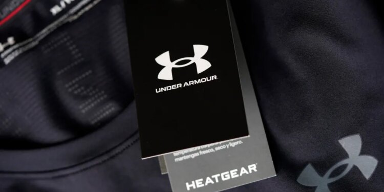 A close-up of a black Under Armour tag with "HeatGear" written below it, hanging from a black compression shirt.