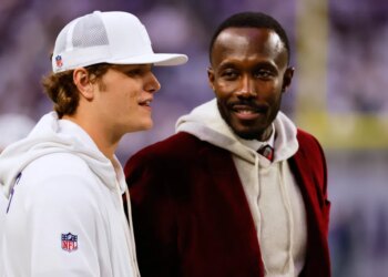 Minnesota Vikings former general manager Kwesi Adofo-Mensah, right, speaks with quarterback J.J. McCarthy before an NFL football game against the Detroit Lions, Thursday, Dec. 25, 2025, in Minneapolis.