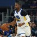 Golden State Warriors forward Jonathan Kuminga dribbling the ball.