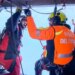Two Italian fire brigade rescue workers inside a helicopter.