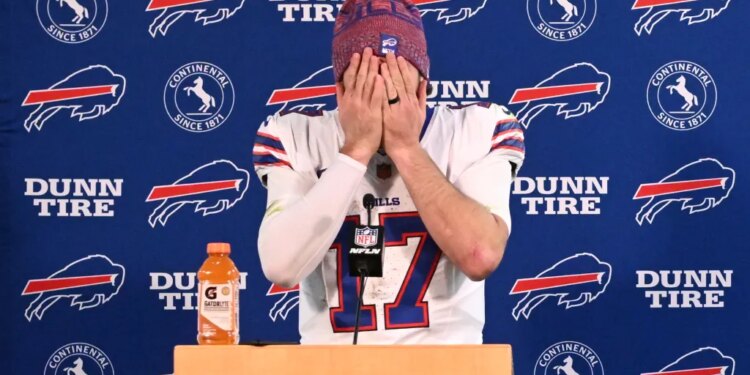 Buffalo Bills quarterback Josh Allen covers his face with his hands at a news conference.