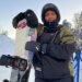 Maryan Hashi holding her snowboard at a ski resort.