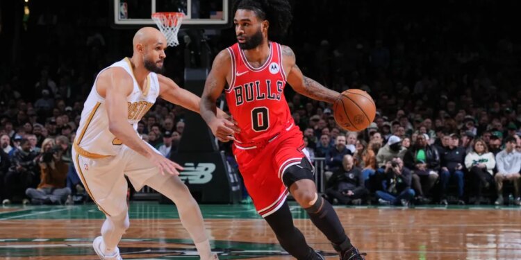 Chicago Bulls player Coby White dribbles the ball past a Boston Celtics defender.